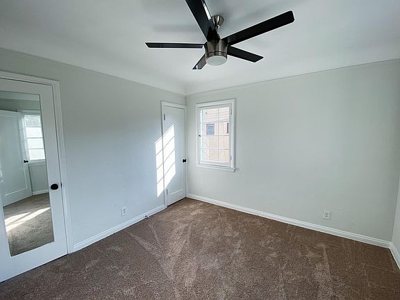 Alternate view of first bedroom with new carpet and ceiling fan