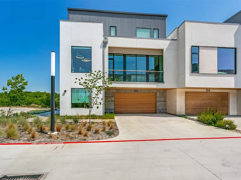 Three-story condominium exterior showcasing modern architecture & finishes.