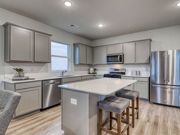 Beautiful Open Kitchen with an island and stainless steel appliances.