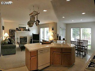 Oak kitchen with gas cooktop flows into sunny nook and family room