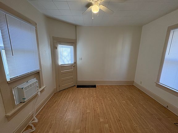 Front room with new ceiling fan, window a/c unit and freshly painted.