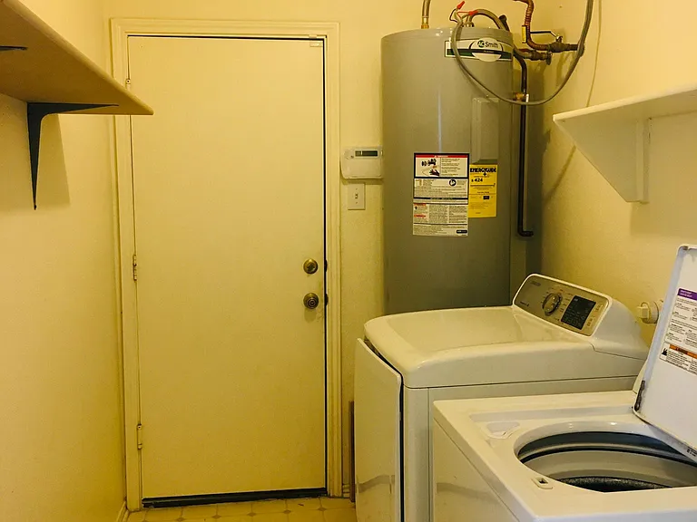 Crossing the kitchen, you will find the pantry room with washing/dry/hot water equitments. They are organized and functional.