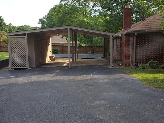 Huge carport with attached workshop, and enlarged parking area.