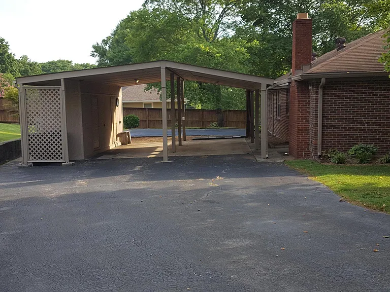Huge carport with attached workshop, and enlarged parking area.