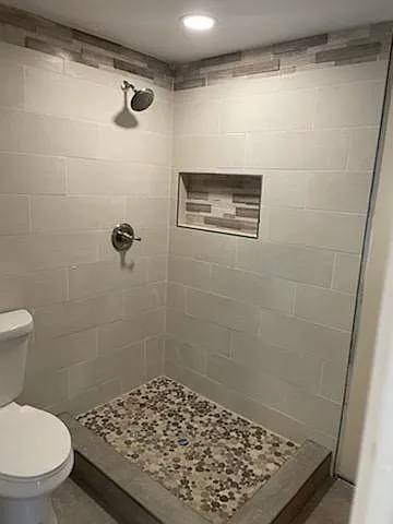 Master Bathroom Shower with Beautiful Tile Work & Beach Pebble Floor Tile