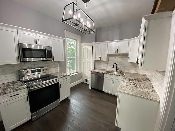 2nd Floor Kitchen! GRANITE, SAMSUNG APPLIANCES, SUBWAY TILE, NEW LIGHTING, LIFEPROOF OAK FLOORS, CUSTOM CABINETS with soft close drawers and crown moulding!