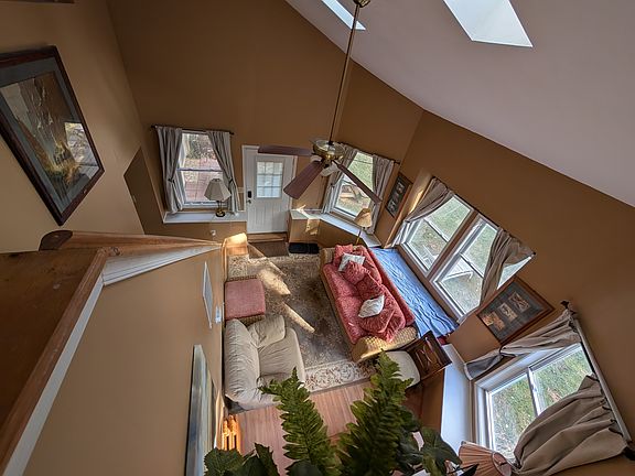 View from loft stairs: bright sunroom with vaulted ceiling and natural light.