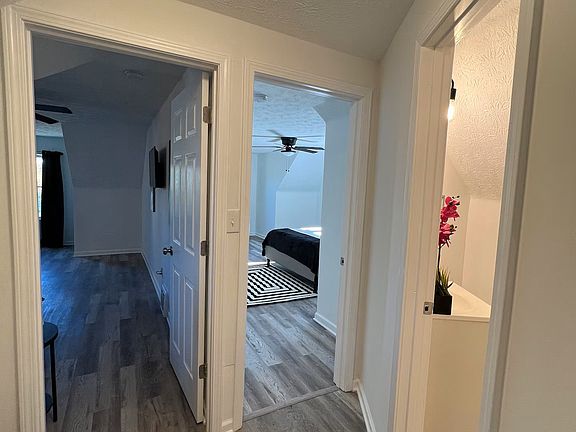 View from hallway looking towards 2 bedrooms and bathroom (on right). Luxury vinyl plank flooring has been installed throughout the entire unit