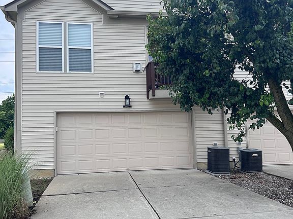 large 2 car garage with small storage room and shelves