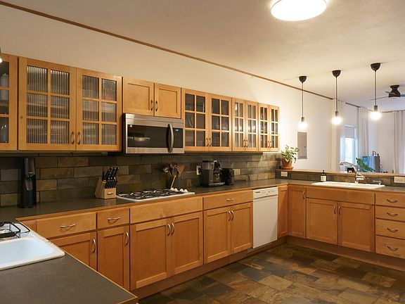 2 sinks with disposals. Natural gas range top under the newly installed microwave. Glass front cabinets. Slate floors. Lots of counterspace!