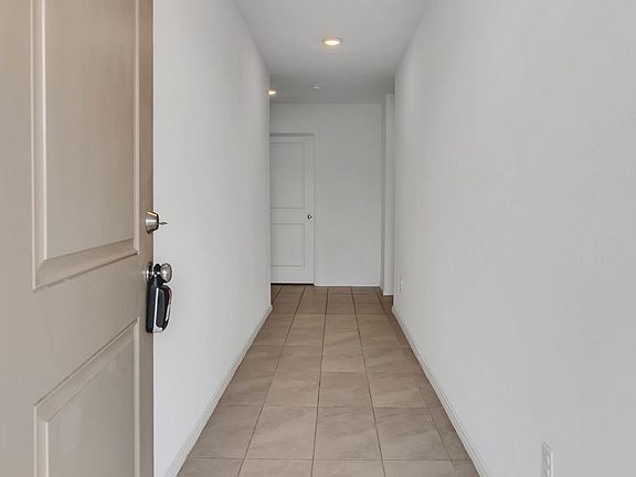 Hallway featuring recessed lighting and light tile patterned floors