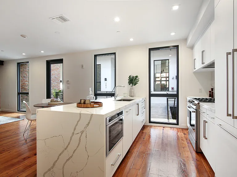 The condo features bookmatched Calacatta quartz countertops and a gas stove.