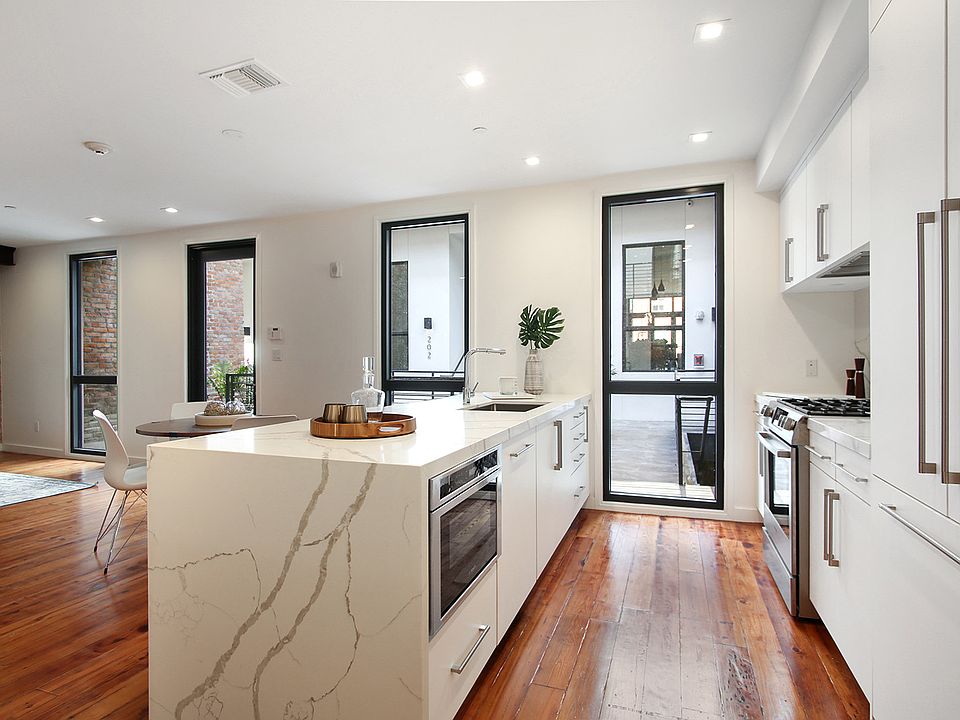 The condo features bookmatched Calacatta quartz countertops and a gas stove.