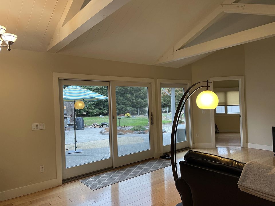 large windows off of the living room have a view of the large backyard