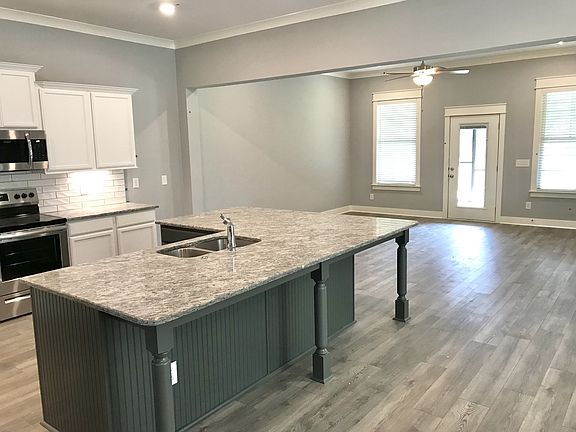 Stock photo showing huge L shaped island with granite. This unit has finished room beyond the back