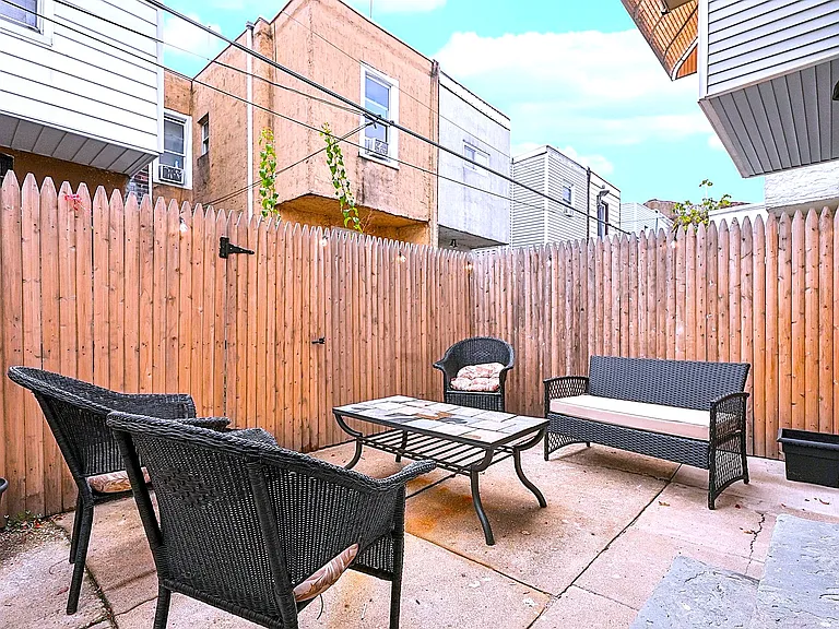 Private fenced in backyard with seating and string lights