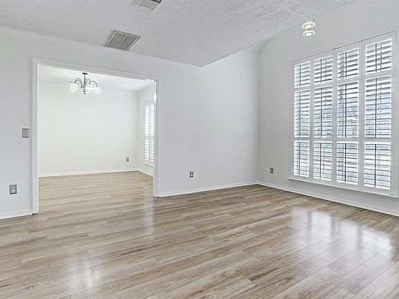 View of the formal living room looking into the formal dining room. Beautiful spaces with a lot of natural light!