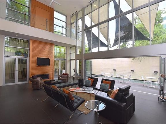 Stunning architecture inside and out!.  Stepping into the home you will enjoy this huge 32x19 Living Room with 24 foot ceilings and walls of glass that look onto the side and backyard areas. There is even a NANA door that brings the outdoors in!
