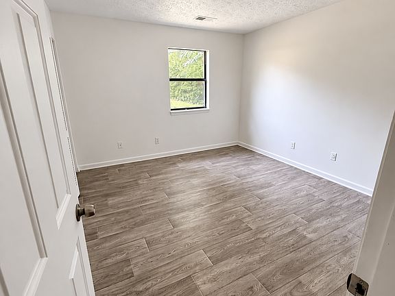 Bedroom with natural light and wood look flooring