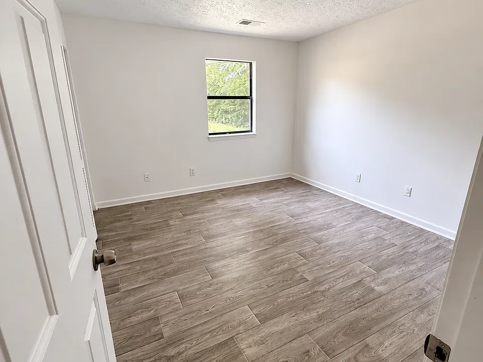 Bedroom with natural light and wood look flooring