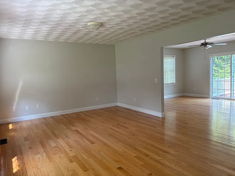 Living room view to dining area, kitchen and slider with deck