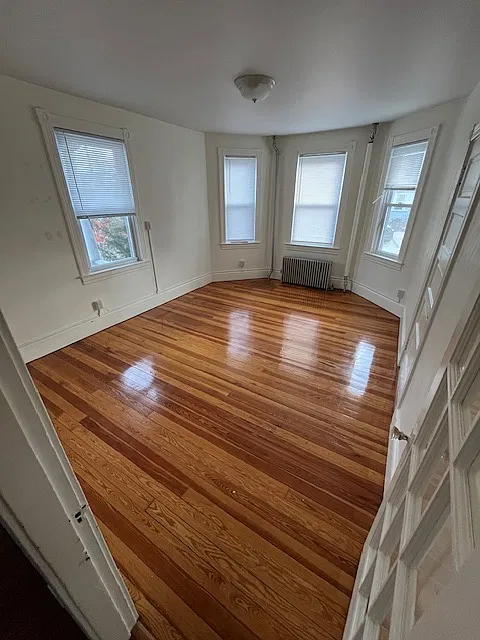 large living room with hardwood floors and bright natural lighting