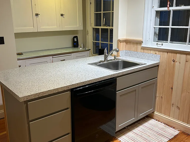 New peninsula with soft close cabinets and new sink. Sitting area behind.