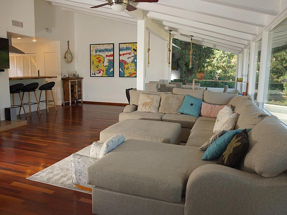 View from the upstairs balcony towards open living room and sofa area.