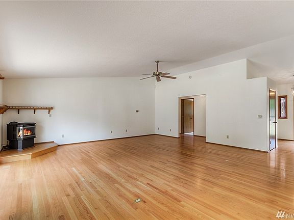 The front entry includes a coat closet and enters into the greatroom with gas stove, ceiling fan, gleaming hardwoods and views f