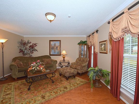 Great formal living room large enough for reading and the study, custom drapery, bright windows
