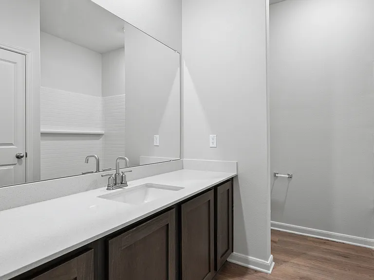 The secondary bathroom has a sprawling vanity space and a shower-tub combo.