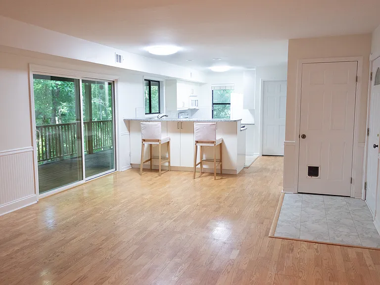To the right, on the west side of the room, you see space for a dining table with the kitchen in the background.