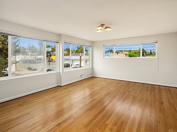 Flooded with natural light and gleaming original hardwoods, this living room impresses.