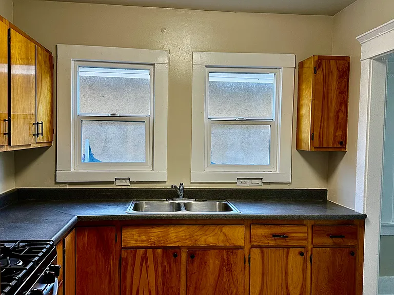 Beutiful kitchen with lots of wood cabinets for storage and cooking.