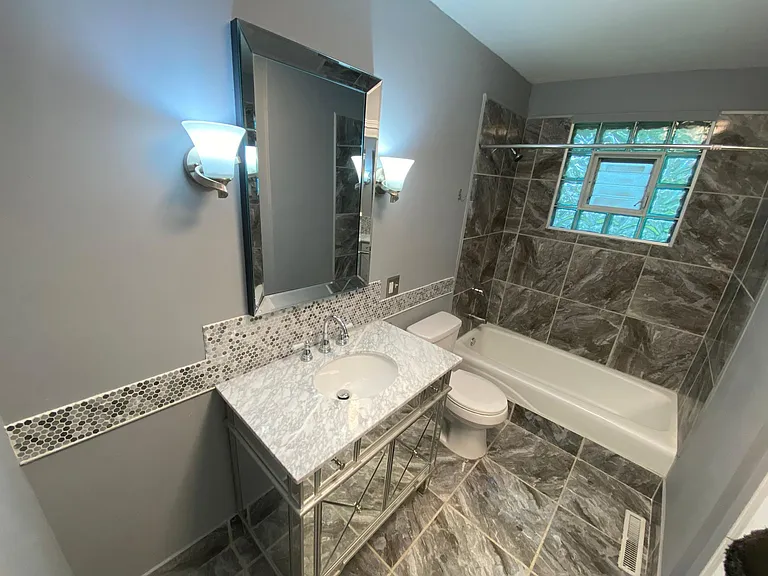 Very large bathroom with tub & mirrored marble vanity. Large closet also in bathroom (not visible).