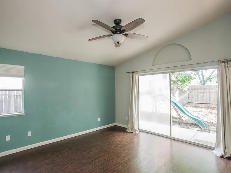 Master bedroom with ceiling fan & lights and sliding door to backyard