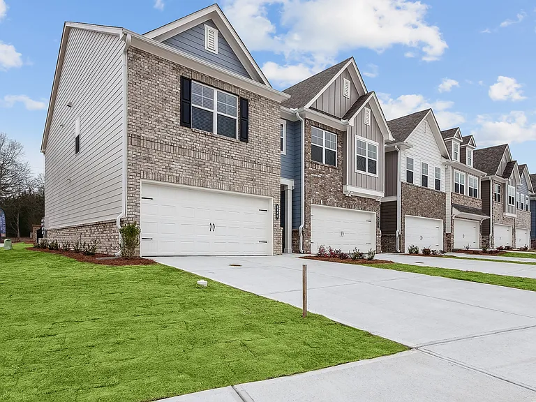 Side view of Carlton Crossing with a private driveway and attached garage.