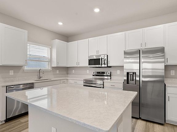 Your sunny kitchen includes an island, pantry, and beautiful finishes - Brynn bungalow by Highland H
