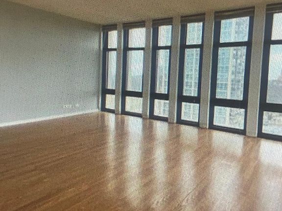 Another view of Living room . Windows wrap around Kitchen and Bedroom.