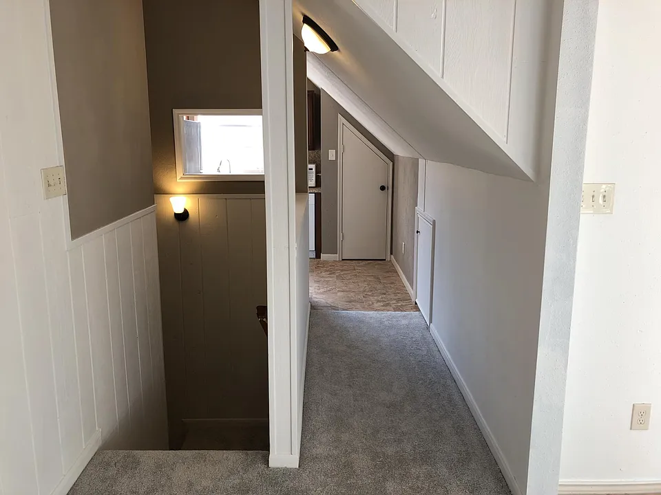 Looking from the living room towards the front entrance/stairwell, and further into the kitchen.