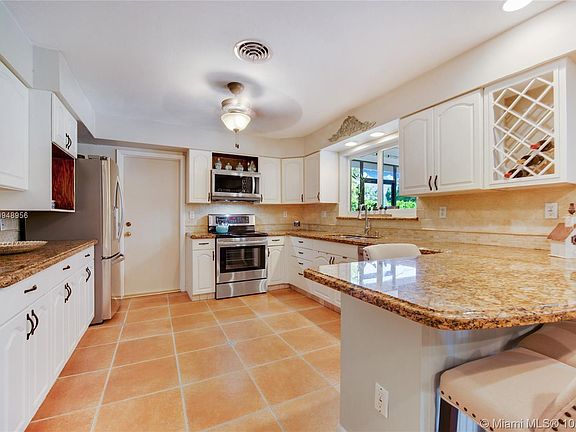 Beautiful kitchen with modern granite, lots of counter space and white cabinets
