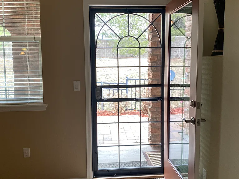 Patio door opens to a long covered porch and open area with garden area and wrought iron fencing. Great outdoor space for grilling and entertaining.