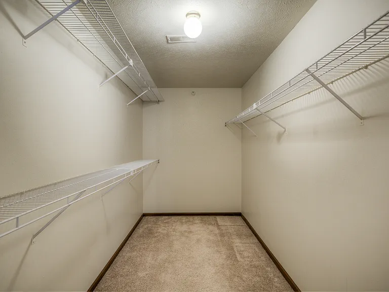 Walk-in closet with shelving at Huntington Apartments.