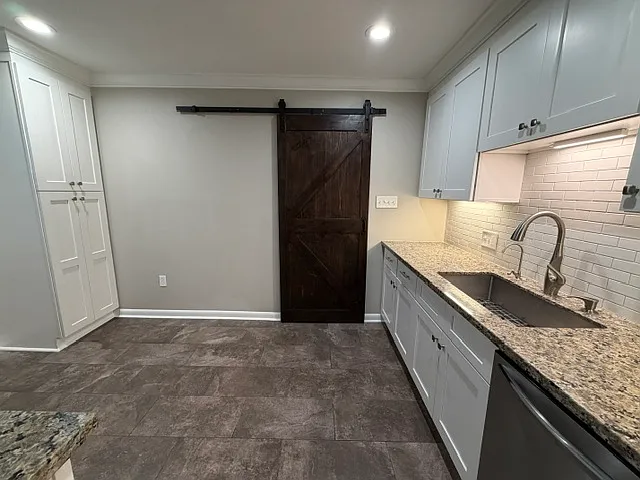Barn door leads to inside laundry room. Granite counters and lots of storage