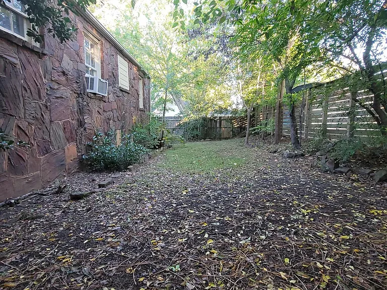 Shaded garden area behind apartment