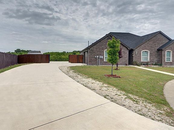 SWING DRIVE WAY WITH THE GATE OPEN WITH EXTRA PARKING ON SIDE OF THE HOME
