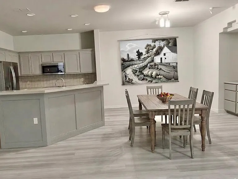 DINING/LIVING Room is staged with a rural farm scene wall hanging.