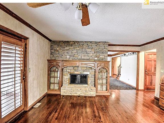 The hearth room in the kitchen feautures a double sided stone fireplace with built-ins and walks-out
