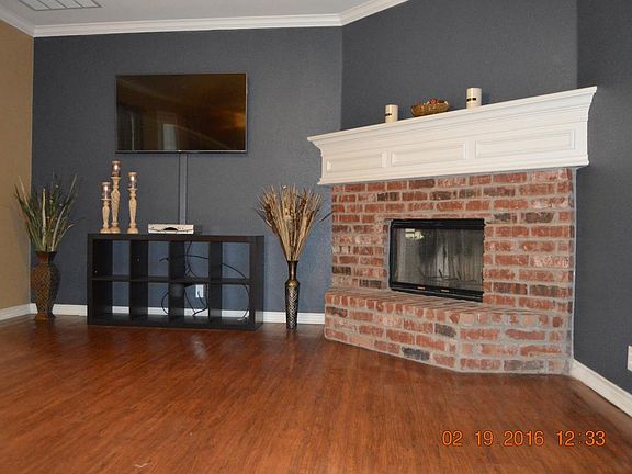 Large living area has brick fireplace.
