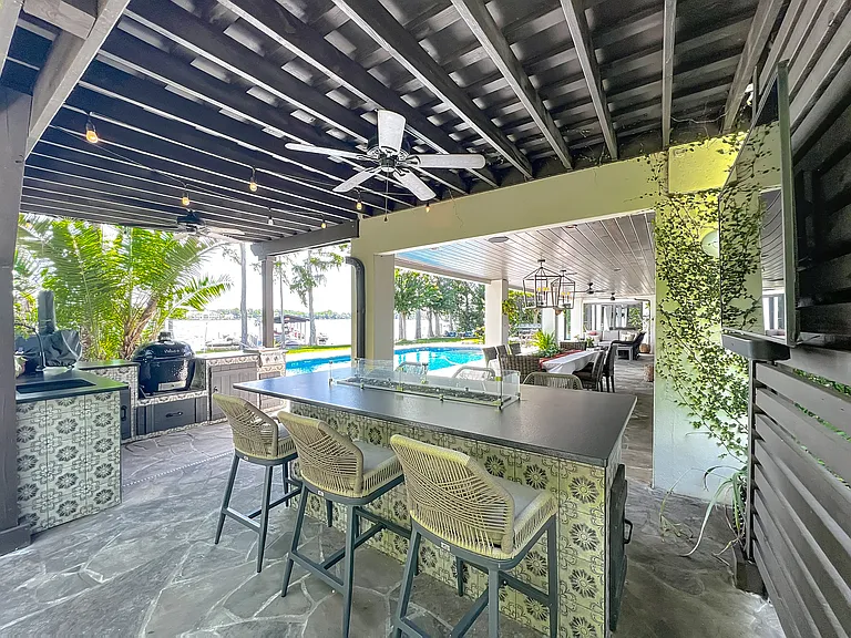 Outdoor Kitchen with sink, fridge, smoker, gas pizza oven and Bar with gas fire pit and TV